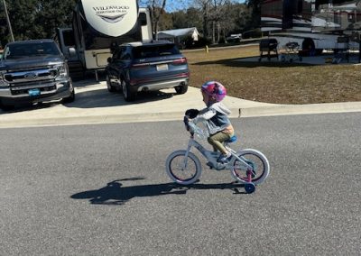 Girl on a bicycle riding through Homestead RV Park in Theodore Alabama